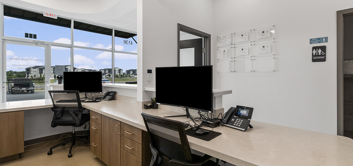 Computer monitors on front desk in dental office