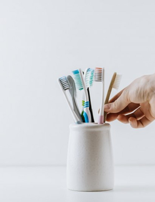 Hand reaches for toothbrush