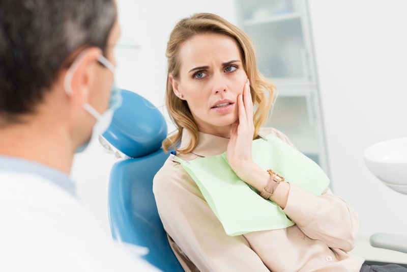 Anxious patient talking to dentist during dental emergency 