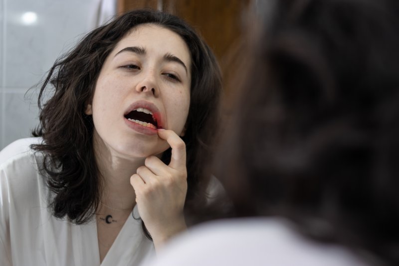 Patient checking irritated gums in the mirror