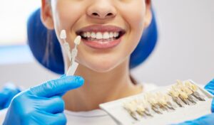 Dentist holding veneers up to smiling patient.